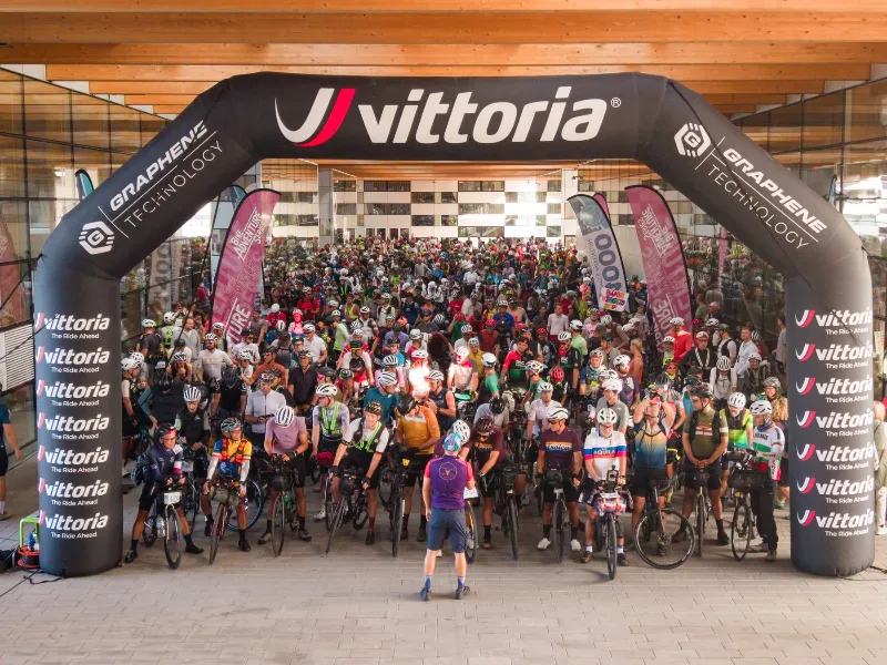 Centinaia di rider con le bici stretti sotto l'arco di partenza a Rovereto, un attimo prima del Grand Depart